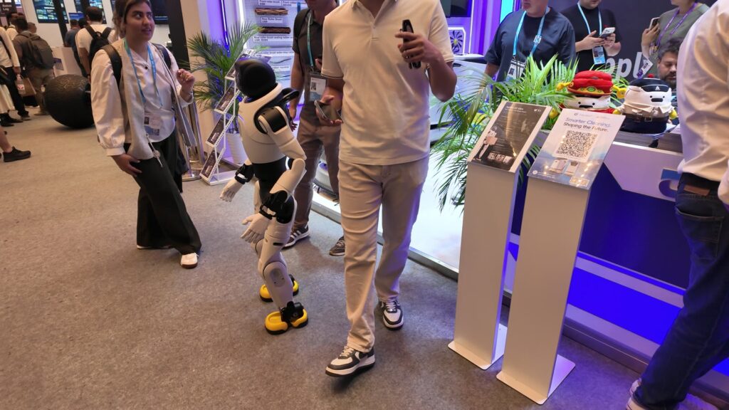 AgiBotの小型ヒューマノイド「X2 Ultra」が来場者の横を歩く