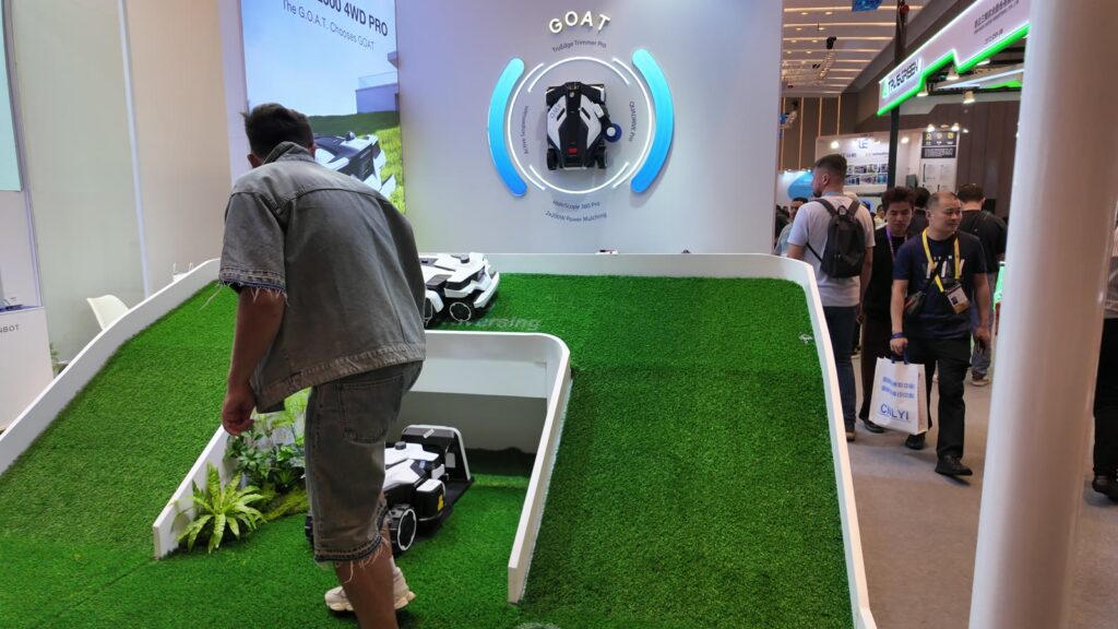 ECOVACSの芝刈りロボ「GOAT」。来場者が人工芝に入って見る
